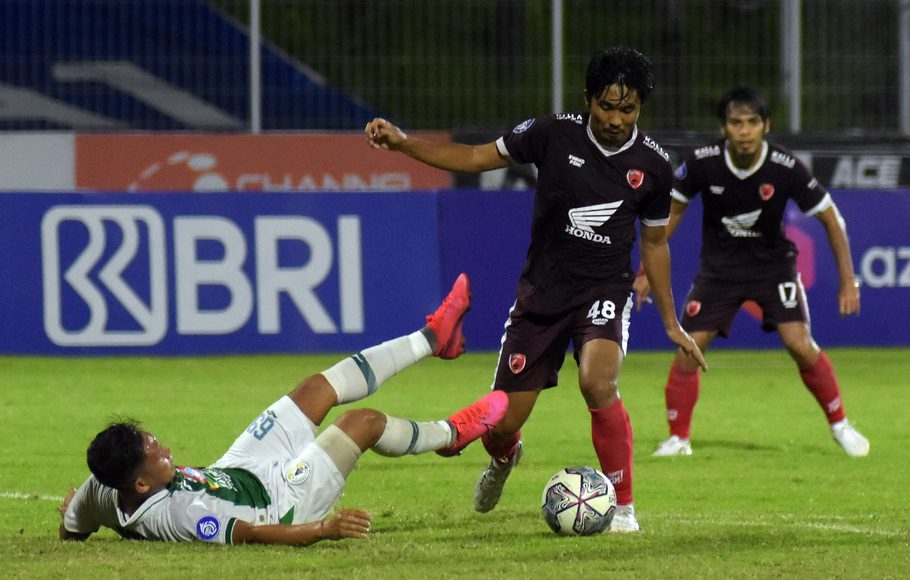 Pemain PSM Makassar Arfan (tengah) beraksi membawa bola.
