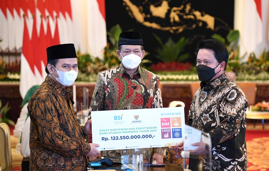 Direktur Utama PT Bank Syariah Indonesia Tbk (BSI) Hery Gunardi (kanan) menyerahkan zakat perusahaan dan zakat non perusahaan melalui BAZNAS sebesar Rp 122,5 Miliar yang oleh Ketua BAZNAS RI Noor Ahmad (tengah) di Istana Negara, Jakarta, Selasa, 12 April 2022.