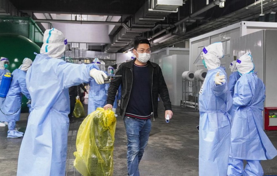 Seorang pasien Covid-19 meninggalkan Pusat Pameran dan Konvensi Nasional (NECC), rumah sakit darurat terbesar, di Shanghai, Tiongkok timur,  pada Kamis 14 April 2022.