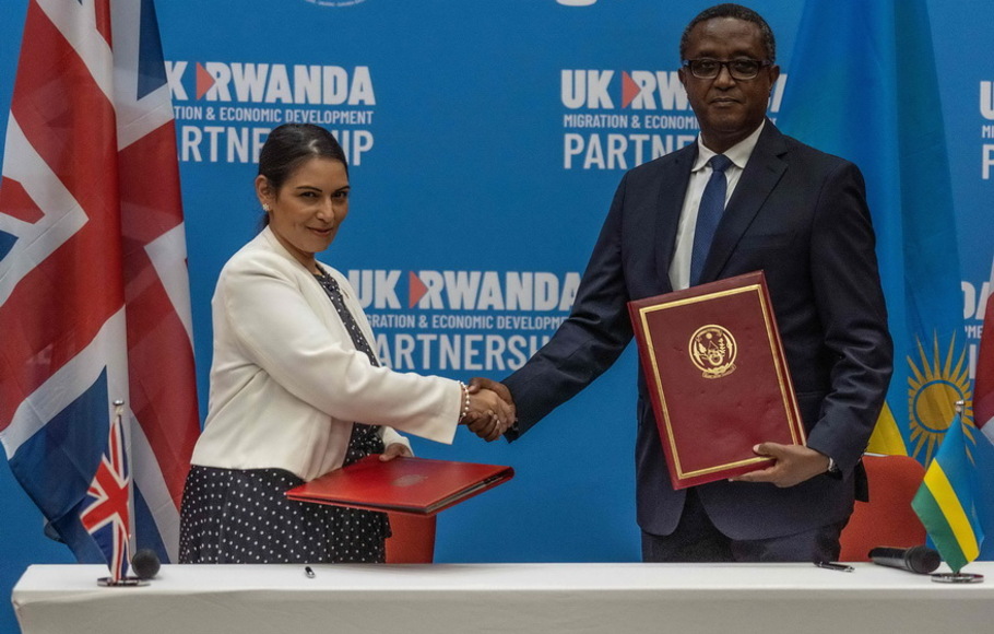 Menteri Dalam Negeri Inggris Priti Patel (kiri), dan Menteri Luar Negeri dan Kerja sama Internasional Rwanda Vincent Biruta, berjabat tangan setelah menandatangani kesepakatan di Kigali Convention Center, Kigali, Rwanda pada Kamis 14 April 2022.