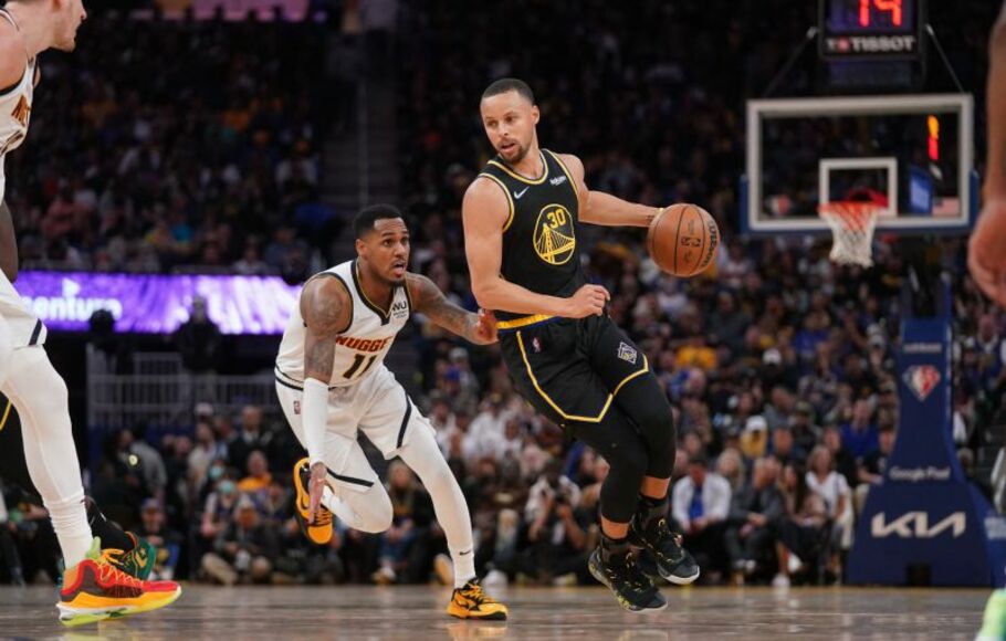Pemain Golden State Warriors Stephen Curry (kanan) membawa bola melewati pemain Denver Nuggets Monte Morris saat kuarter keempat pertandingan NBA Playoff.