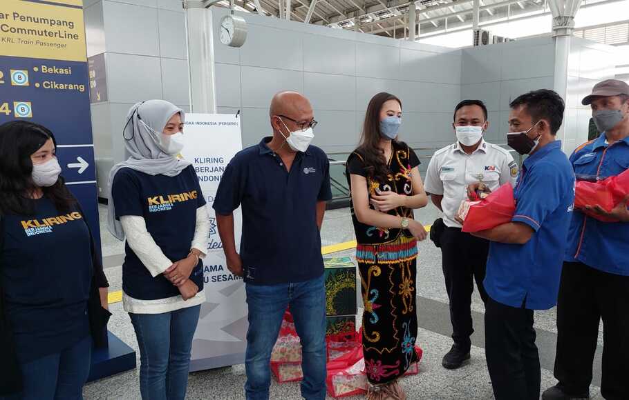 Direktur Utama PT Kliring Berjangka Indonesia, Fajar Wibhiyadi (ketiga dari kiri), Ketua Arkadewi KBI Fuji Dwi Nurfitri (Kedua dari Kiri), tengah menyampaikan paket bantuan kepada para porter di Stasiun Jatinegara, Kamis 21 April 2022.
