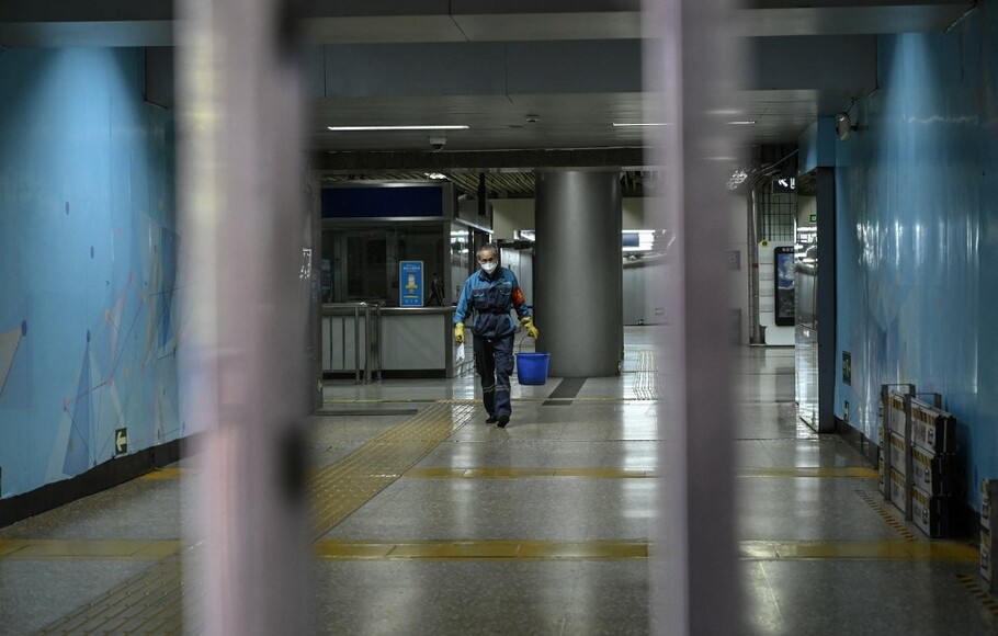 Seorang petugas kebersihan terlihat di stasiun kereta bawah tanah yang ditutup di kawasan pusat bisnis di Beijing pada 4 Mei 2022.