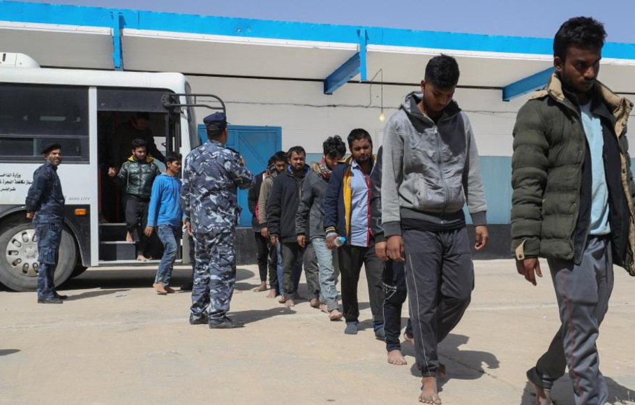 Para migran turun dari bus di pusat penerimaan Tariq al-Matar, tempat mereka akan menerima bantuan kemanusiaan sebelum dideportasi ke negara asal mereka, di Tripoli, Libia, pada 24 April 2022.