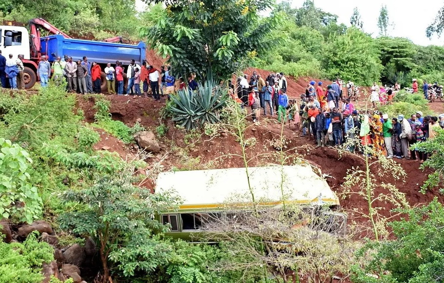 Foto dokumentasi menunjukkan orang-orang melihat reruntuhan bus yang telah mengangkut siswa sekolah dasar dari Arusha ke Karatu di Tanzania sebelum terjun ke jurang, dan menewaskan sedikitnya 29 anak, dua guru dan sopir, pada 6 Mei 2017. 