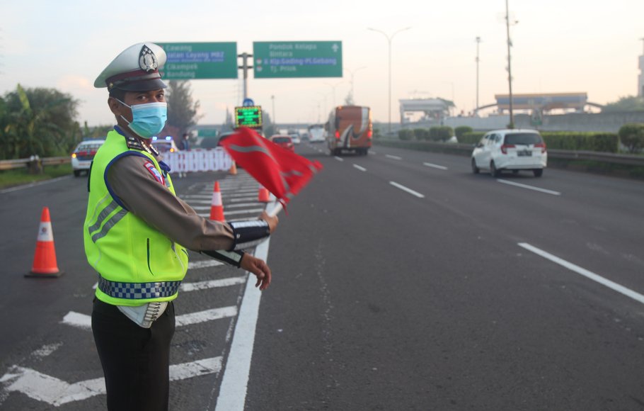 Petugas Kepolisian berjaga di pintu masuk Tol Layang MBZ yang ditutup untuk kelancaran arus mudik dengan sistem One Way dari Tol Cikampek ke arah Jakarta, Sabtu, 7 Mei 2022.