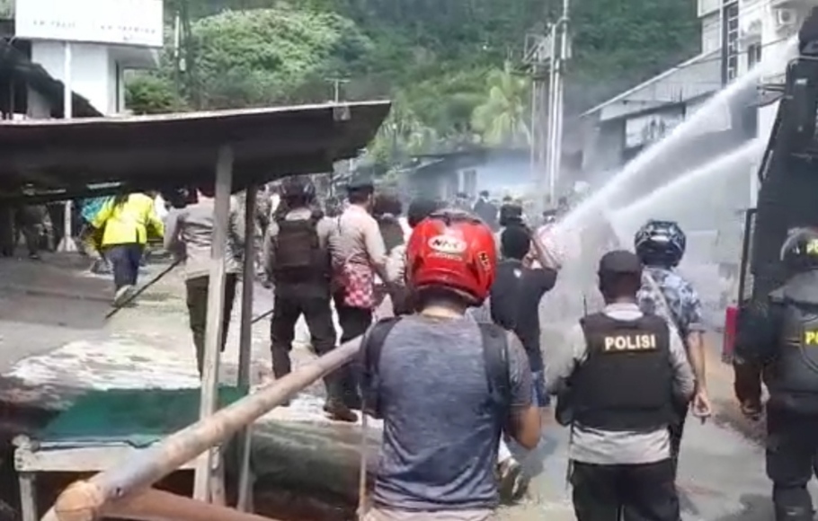 Aparat gabungan saat membubarkan massa aksi unjuk rasa dengan water cannon di Jayapura, Selasa, 10 Mei 2022.