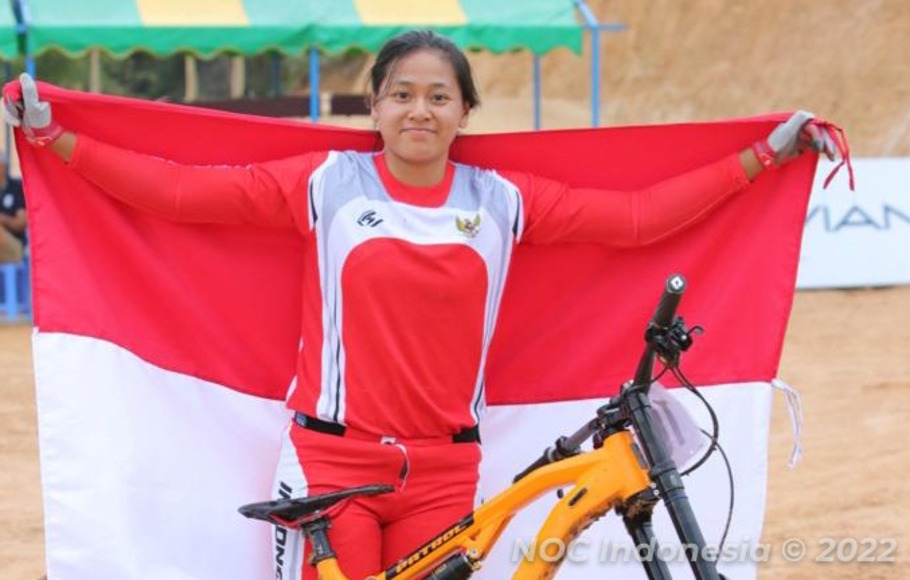 Atlet sepeda Tiara Prastika Andini mengibarkan bendera Merah Putih di depan sepedanya usai berhasil mempersembahkan emas untuk Indonesia dari Cycling MTB nomor Women's Mountain Bike Downhill Individual. 