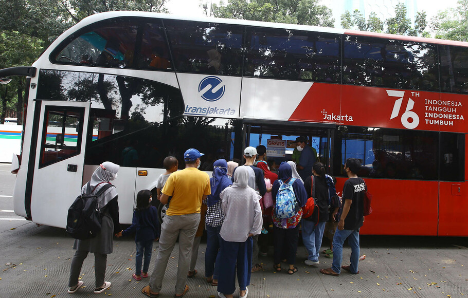 Warga antre untuk masuk ke dalam bus wisata gratis Transjakarta di kawasan IRTI Monas, Jakarta, Senin, 16 Mei 2022.