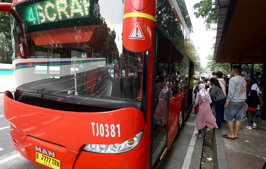 Warga antre untuk masuk ke dalam bus wisata gratis Transjakarta di kawasan IRTI Monas, Jakarta, Senin, 16 Mei 2022.