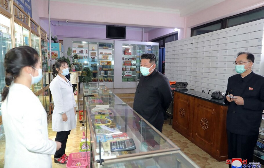 Gambar dari KCNA pada 16 Mei menunjukkan pemimpin Korea Utara Kim Jong-un (tengah) memeriksa apotek di Pyongyang.