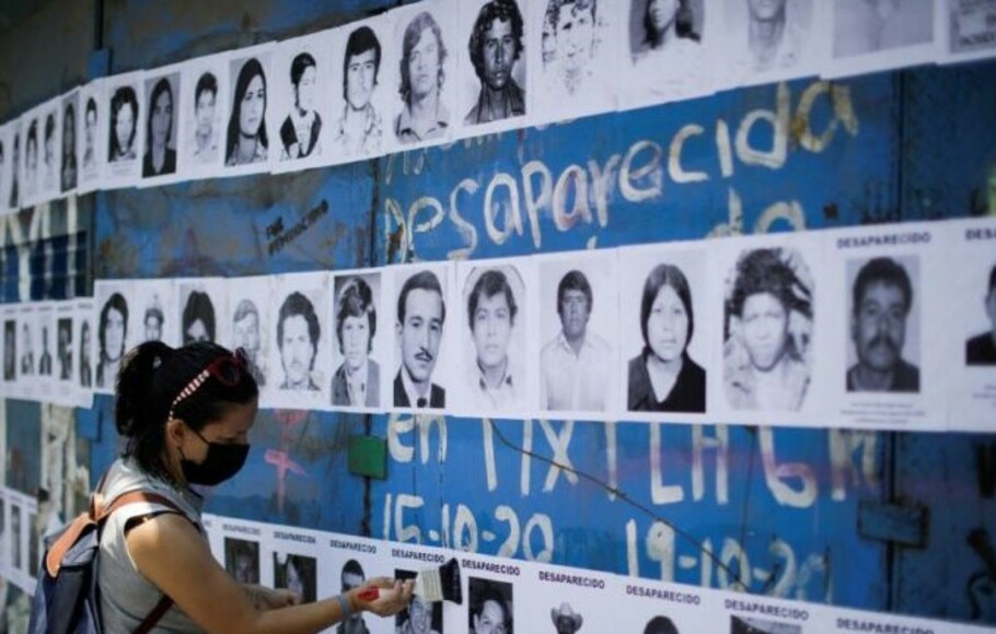 Seorang warga memasang foto kerabat yang hilang di Mexico City, 15 Mei 2022.