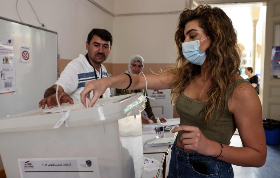 Seorang wanita Lebanon memberikan suaranya di tempat pemungutan suara saat dia memberikan suara untuk pemilihan parlemen di ibu kota Beirut, pada 15 Mei 2022. -