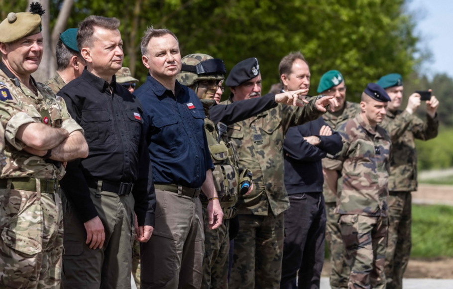 Presiden Polandia Andrzej Duda (ketiga dari kiri) dan menteri pertahanan Polandia Mariusz Blaszczak (kedua dari kiri) melihat pasukan dari Polandia, AS, Prancis, dan Swedia mengambil bagian dalam latihan militer DEFENDER-Europe 22, di Nowogrod, Polandia pada Kamis 19 Mei, 2022. 