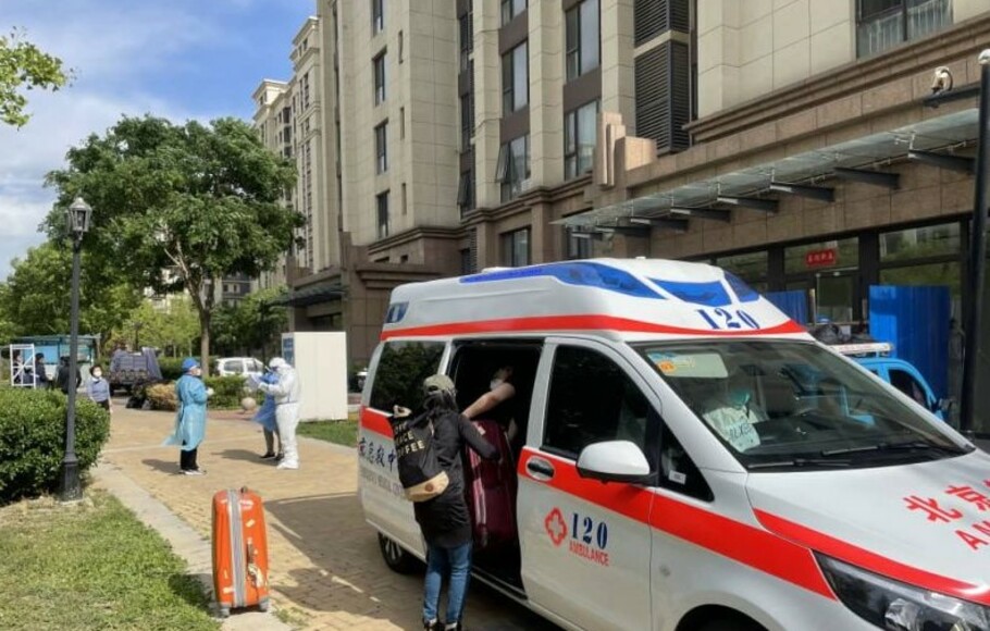 Ambulans Satgas Covid-19 Kota Beijing, Tiongkok, menjemput warga yang tinggal di salah satu apartemen di Distrik Shunyi pada 13 Mei 2022 untuk dibawa ke pusat karantina terpadu setelah ada satu kontak dekat kasus positif.
