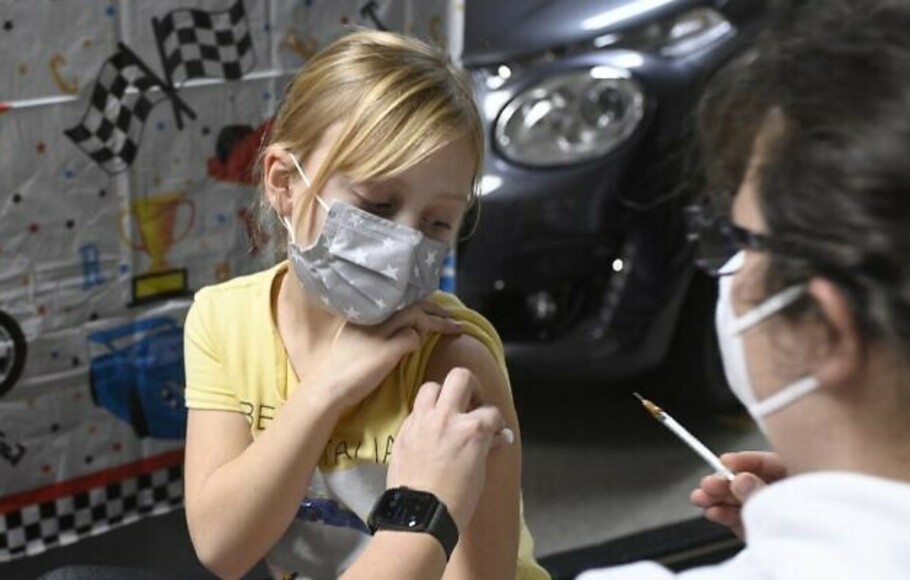 Hanna yang berusia enam tahun disuntik dengan vaksin Pfizer-BioNTech untuk anak-anak di pusat vaksinasi yang didirikan di satu dealer mobil di Iserlohn, Jerman barat, pada 5 Januari 2022. 