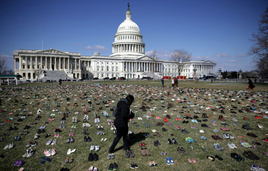Dalam foto dokumentasi pada 13 Maret 2018 ini, 7.000 pasang sepatu, mewakili anak-anak yang terbunuh oleh kekerasan penembakan senjata sejak 2012, tersebar di sisi timur US Capitol di Washington, AS. 