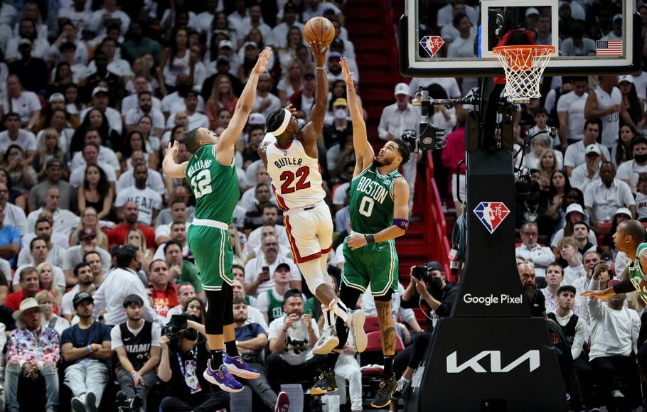 Pemain Miami Heat Jimmy Butler mencoba menembak bola melawan Grant Williams dan Jayson Tatum dari Boston Celtics pada pertandingan ketujuh dari final NBA wilayah timur di FTX Arena, Miami,
