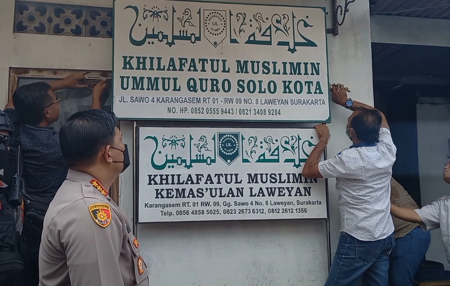 Petugas mencopot plang yang ada di kantor Khilafatul Muslimin di Kota Solo, Jawa Tengah, Kamis, 9 Juni 2022.