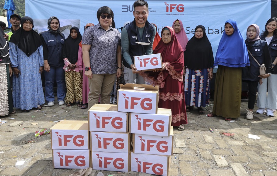 Relawan BUMN Indonesia Financial Group (IFG) bersama Sekretaris Desa Malasari Suryati (kiri) secara simbolis menyerahkan bantuan sembako kepada warga di Desa Malasari, Kecamatan Nanggung, Bogor, Jawa Barat.