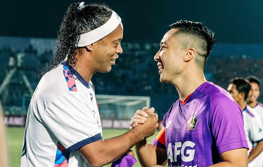 Ronaldinho yang memperkuat Rans Nusantara (kiri) bersalaman dengan pemain Persik Kediri, Arthur Irawan.