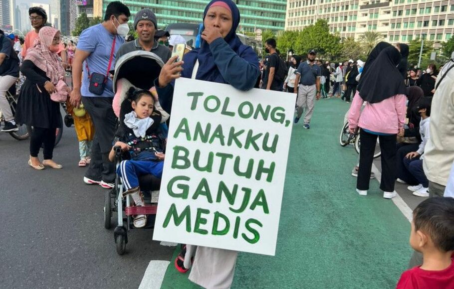 Unggahan foto seorang ibu membawa poster bertuliskan butuh ganja medis saat hari bebas kendaraan di Bundaran HI, Jakarta, Minggu 26 Juni 2022