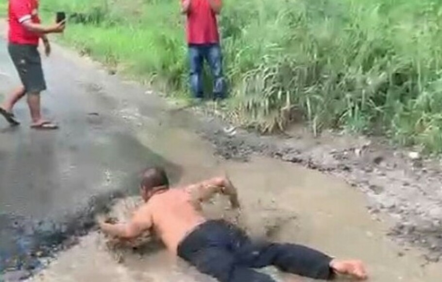 Tangkapan layar video seorang pria mandi lumpur di kubangan jalan poros Kecamatan Palas, Lampung Selatan, Provinsi Lampung, Selasa, 5 Juli 2022.