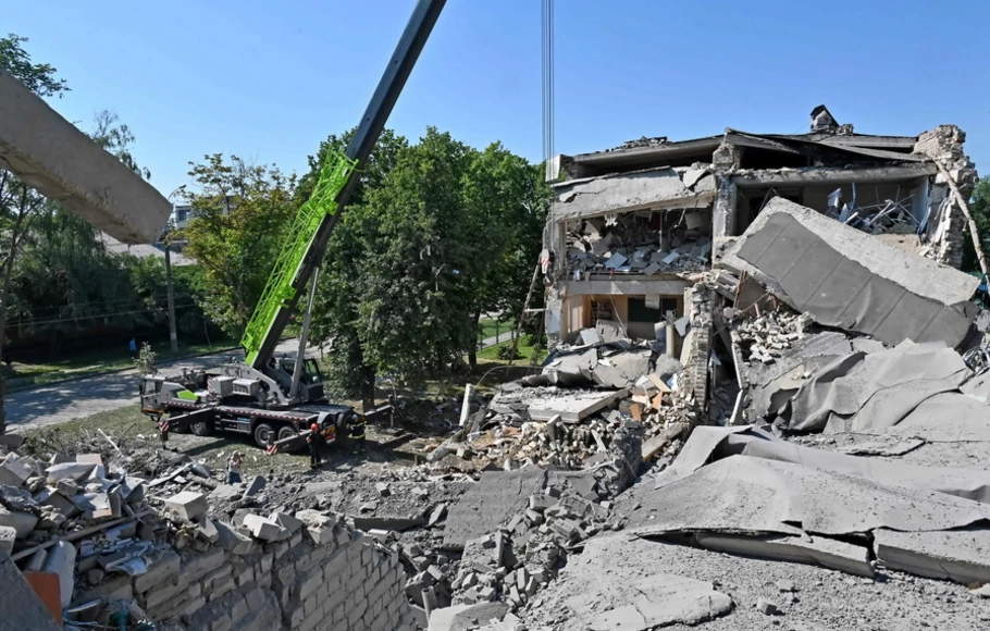 Tim penyelamat bekerja di puing-puing sekolah yang hancur setelah terkena roket di Kharkiv, Ukraina pada Senin 4 Juli 2022.