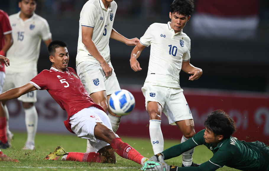 Pemain Indonesia U-19 Kakang Rudianto (kiri) mencoba merebut bola mendahului kiper Thailand U-19 Narongsak Naengwongsa dalam laga penyisihan grup A Piala AFF U-19 di Stadion Patriot Candrabhaga, Bekasi, Jawa Barat, Rabu, 6 Juli 2022.