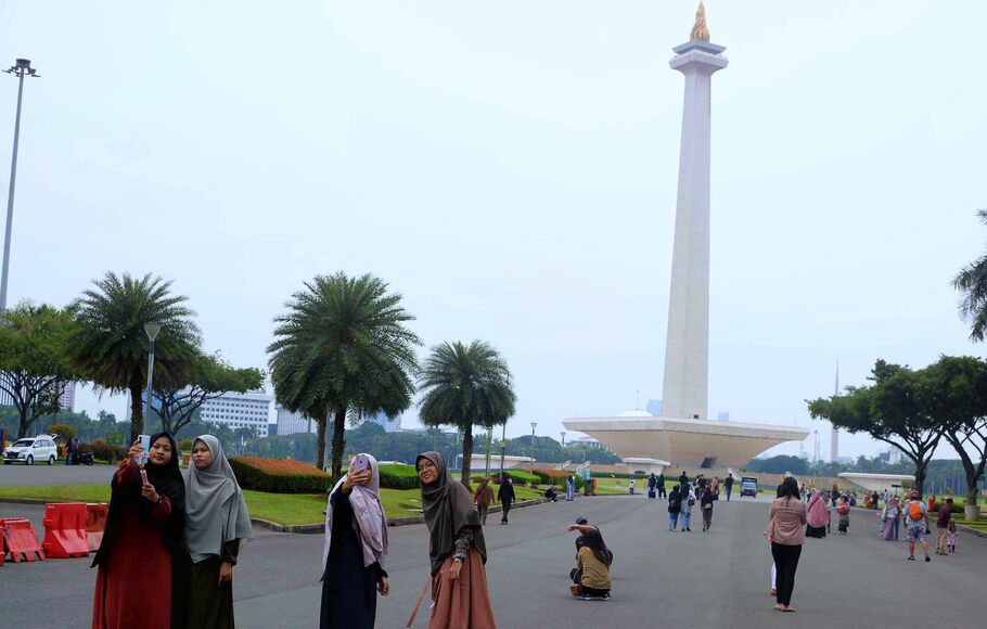 Sejumlah pengunjung saat berwisata di kawasan Monas, Jakarta.