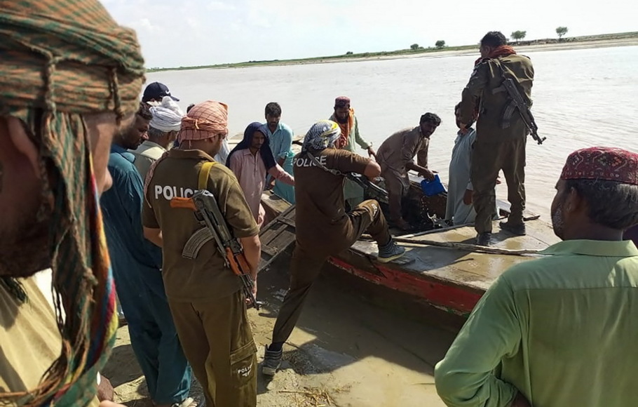 Polisi dan penduduk desa setempat bersiap untuk mencari korban tenggelam di Sungai Indus setelah kapal yang penuh sesak yang membawa pesta pernikahan Pakistan terbalik di pinggiran kota Sadiqabad, Pakistan pada Senin 18 Juli 2022.