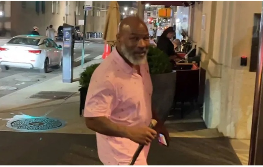 Tangkapan layar dari video yang menunjukkan Mike Tyson berjalan dengan memakai tongkat.