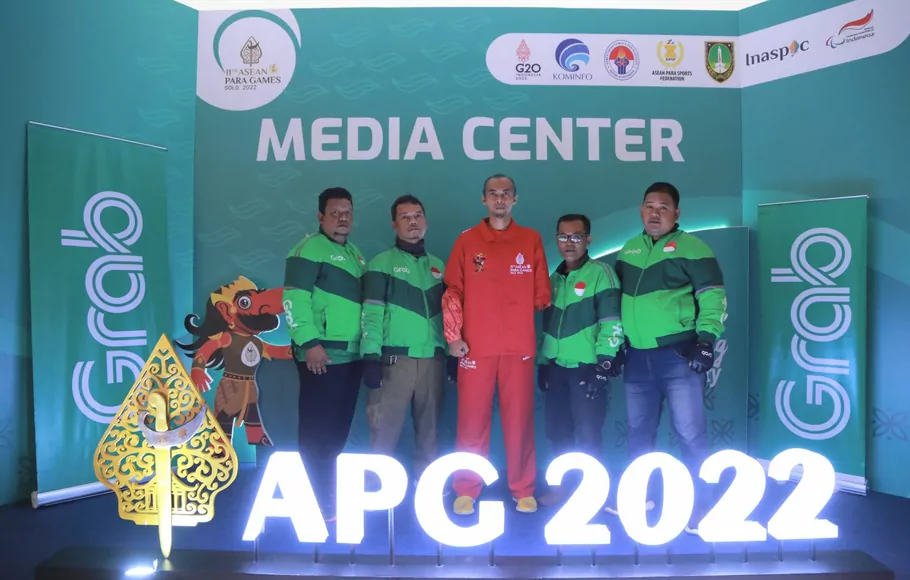 Perwakilan mitra pengemudi Grab yang menjadi sukarelawan ASEAN Para Games 2022 berfoto bersama atlet lompat jauh Setyo Budi Hartanto (tengah).