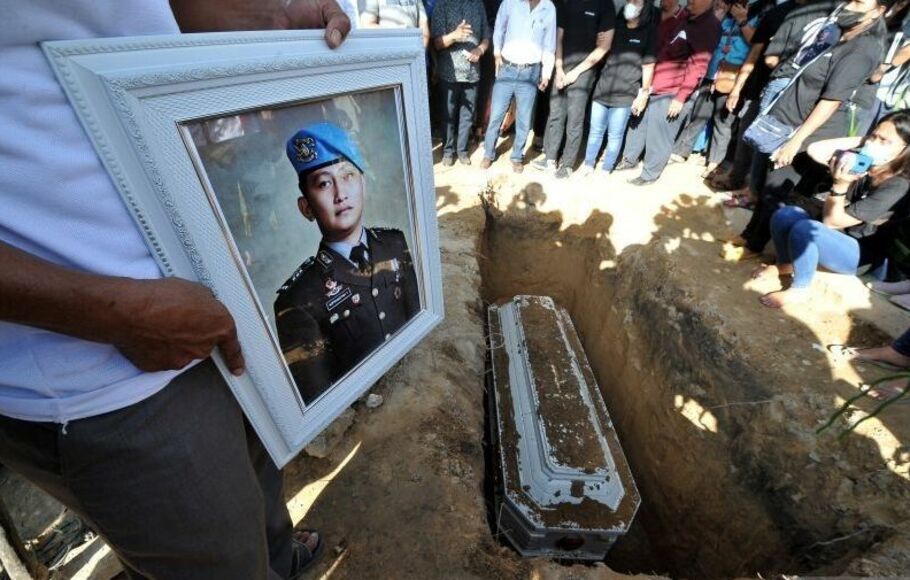 Kerabat memegang foto almarhum Brigadir Nofriansyah Yosua Hutabarat atau Brigadir J saat pemakaman kembali jenazah setelah autopsi ulang di Sungai Bahar, Muarojambi, Jambi, Rabu, 27 Juli 2022.  