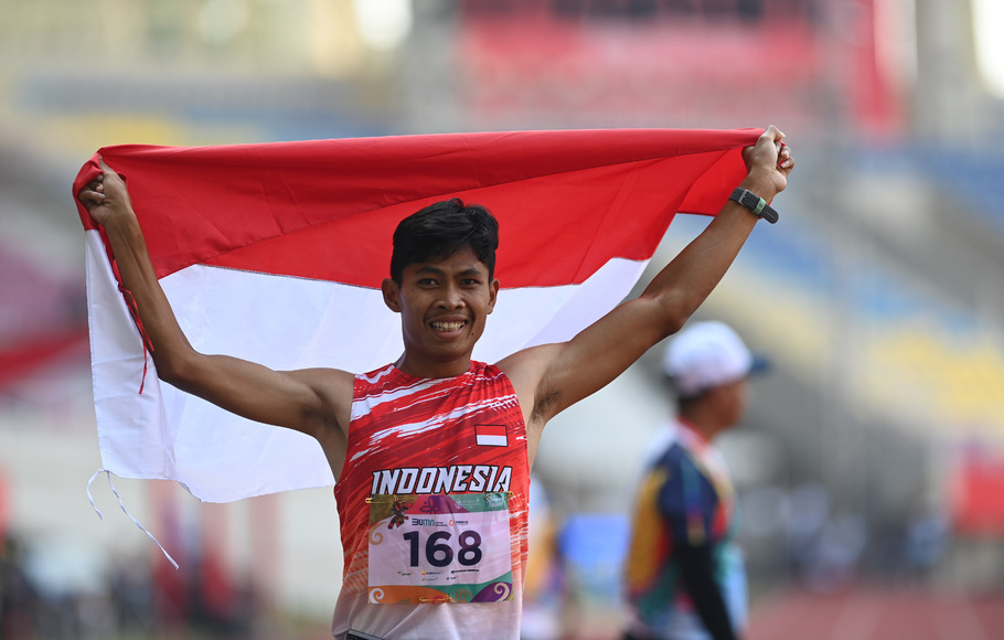Pelari Indonesia Sapto Yogo Purnomo membentangkan bendera usai mencapai garis finis pada final lari 400 meter putra T37 ASEAN Para Games 2022 di Stadion Manahan, Solo, Jawa Tengah, Rabu, 3 Agustus 2022. Sapto berhasil meraih medali emas dengan catatan waktu 55,80 detik. 