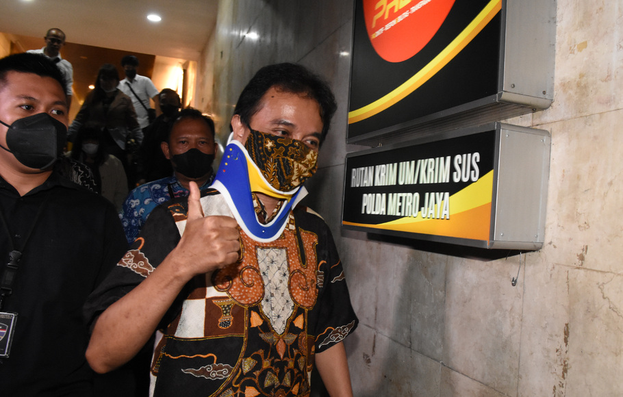 Petugas mengawal mantan Menteri Pemuda dan Olahraga Roy Suryo (kanan) menuju rumah tahanan seusai menjalani pemeriksaan di Direktorat Reskrimum Polda Metro Jaya, Jakarta, Jumat, 5 Agustus 2022.