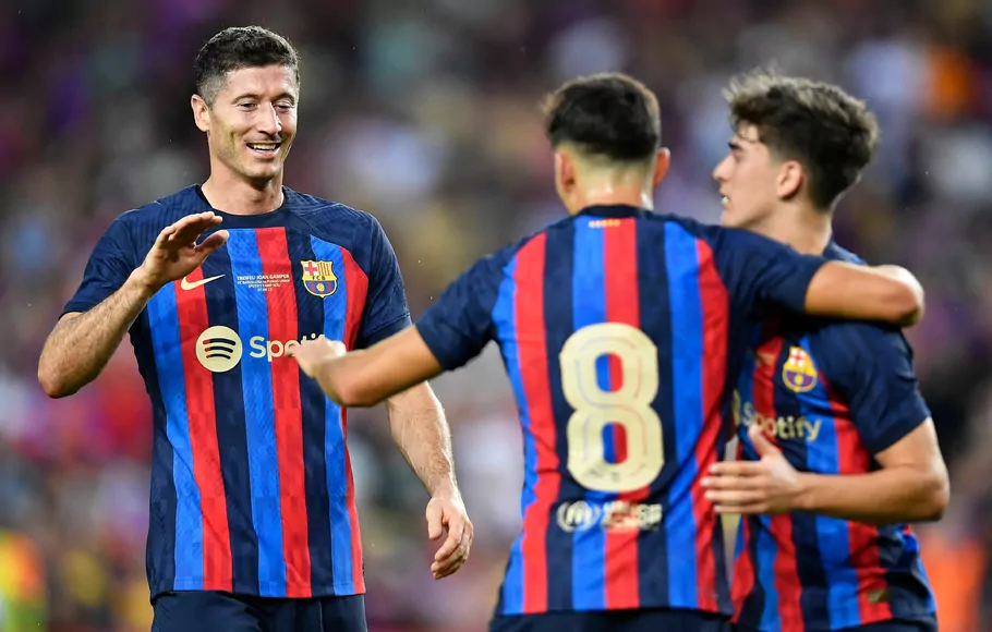 Striker Barcelona, Robert Lewandowski bersama rekannya Pedri dan Gavi melakukan selebrasi usai mencetak go ke gawang Pumas di Nou Camp, Senin, 8 Agustus 2022.