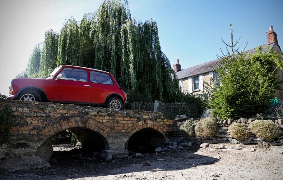 Sebuah Mobil antik diparkir di jalan masuk di atas dasar sungai yang kering dari aliran Sungai Thames, di Ashton Keynes, pada 8 Agustus 2022.