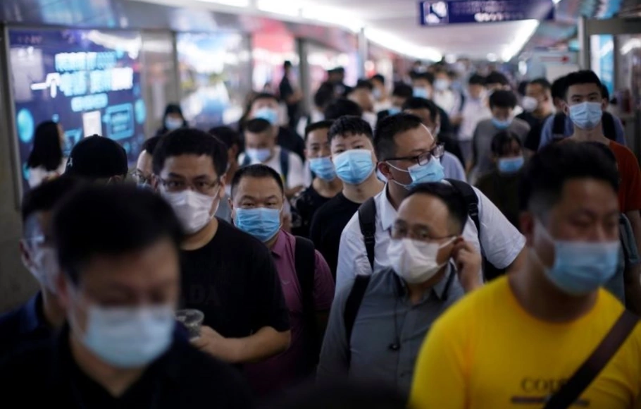 Warga memakai masker pelindung tiba di Stasiun Kereta Yiwu menyusul penyebaran Covid-19 di Yiwu, Provinsi Zhejiang, Tiongkok.
