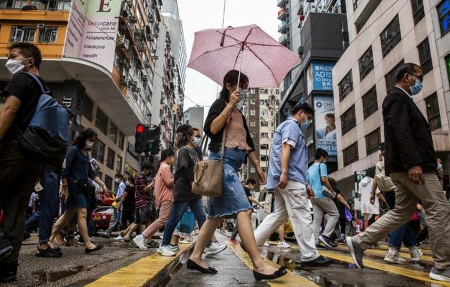Para pejalan kaki melintas di jalan di distrik Wan Chai, Hong Kong pada 6 Agustus 2021. 
