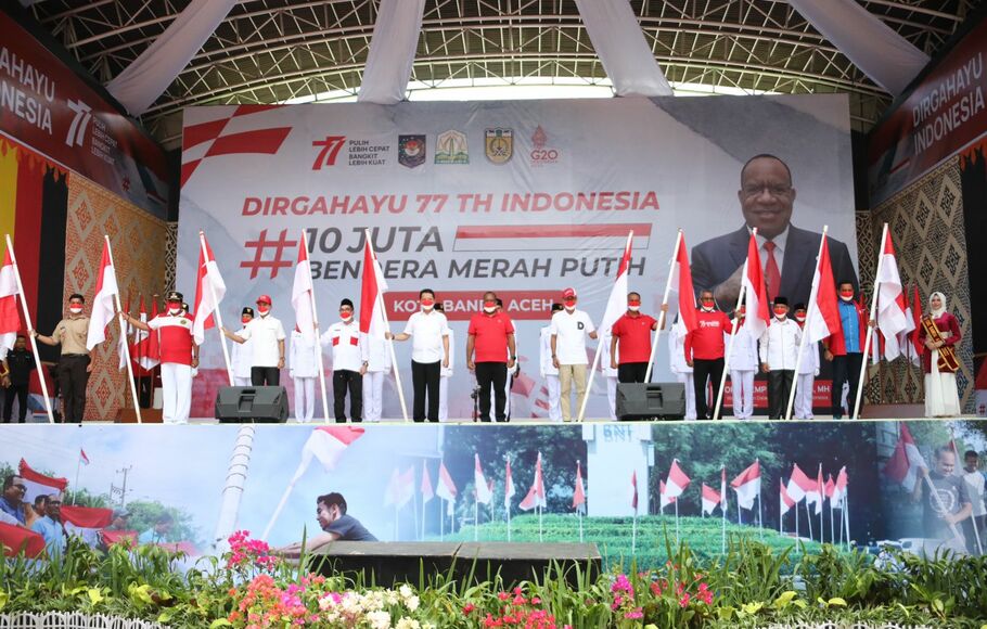 Wakil Menteri Dalam Negeri (Wamendagri) John Wempi Wetipo menyerahkan secara simbolis bendera merah putih kepada masyarakat di Aceh.