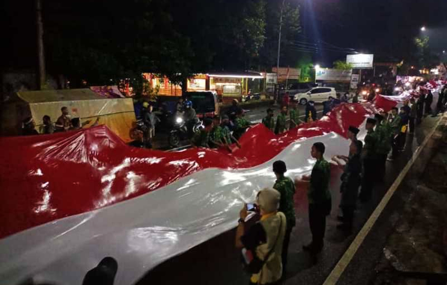 Dalam suasana hujan, tidak menyurutkan semangat para peserta parade Merah Putih untuk melakukan kirab bendera Merah Putih sepanjang 100 meter di Borobudur, Sabtu 13 Agustus 2022 malam.