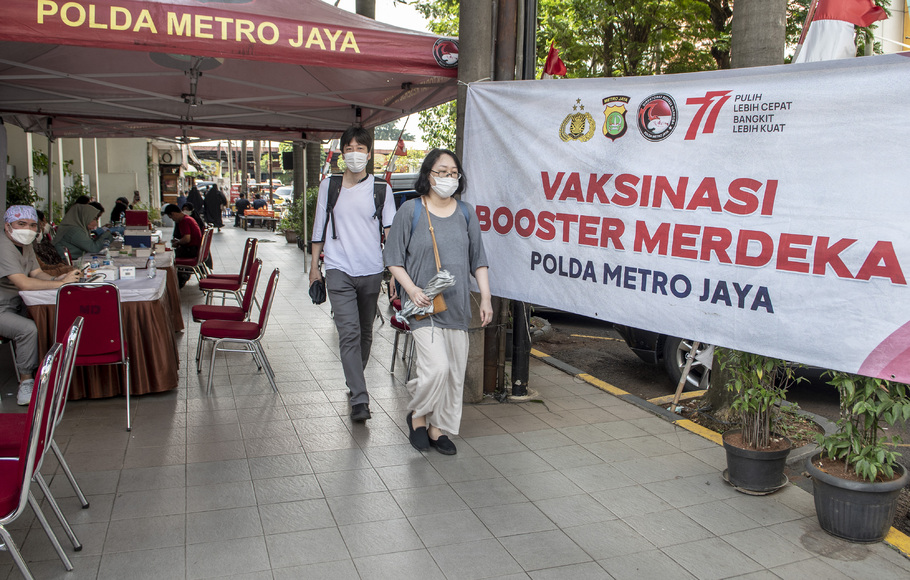 Warga melintas di tenda lokasi vaksinasi booster Covid-19 di kawasan Blok M, Jakarta, Minggu 14 Agustus 2022.