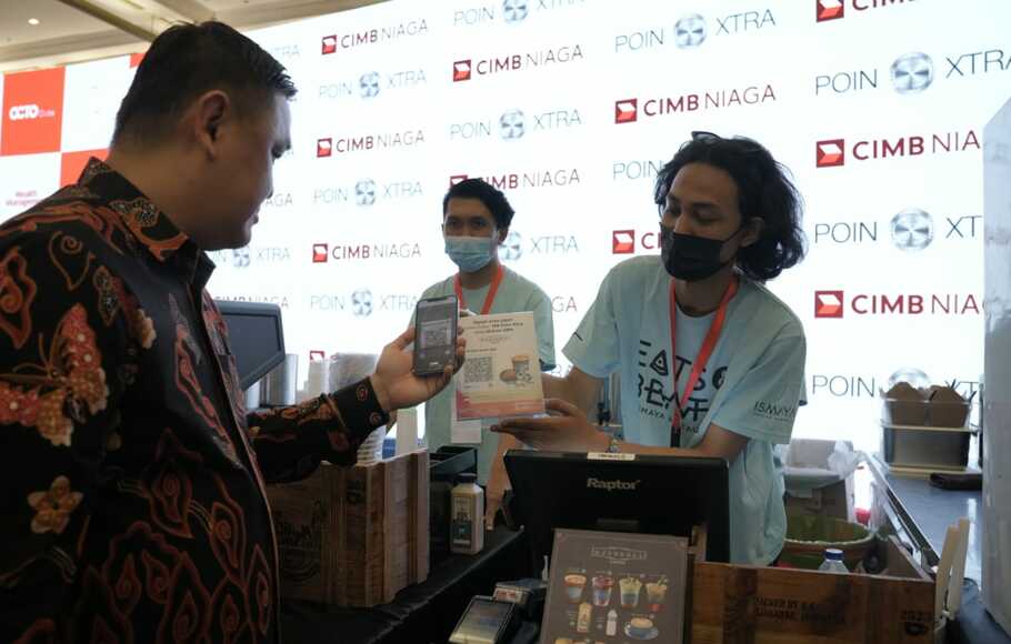 Direktur Consumer Banking CIMB Niaga Noviady Wahyudi mendemonstrasikan penukaran Poin Xtra melalui Super App OCTO Mobile untuk berbelanja di booth merchant yang ada di area Konser Kejar Mimpi, Jakarta Convention Center, Kamis malam, 18 Agustus 2022.