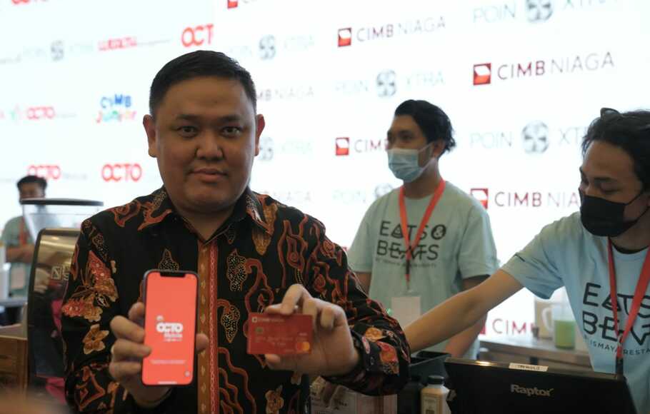 Direktur Consumer Banking CIMB Niaga Noviady Wahyudi memperlihakan Super App OCTO Mobile untuk berbelanja di booth merchant yang ada di area Konser Kejar Mimpi, Jakarta Convention Center, Kamis malam, 18 Agustus 2022.