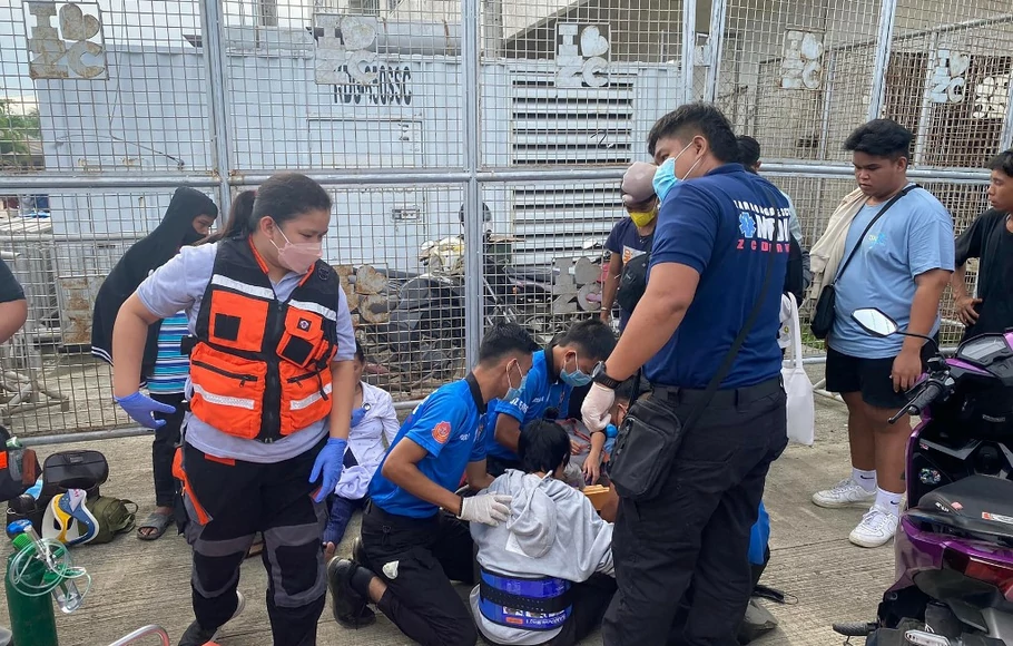 Petugas medis memberi pertolongan setelah puluhan orang terluka karena berebut bantuan tunai pendidikan menjelang pembukaan kembali sekolah, di Kota Zamboanga, Filipina.