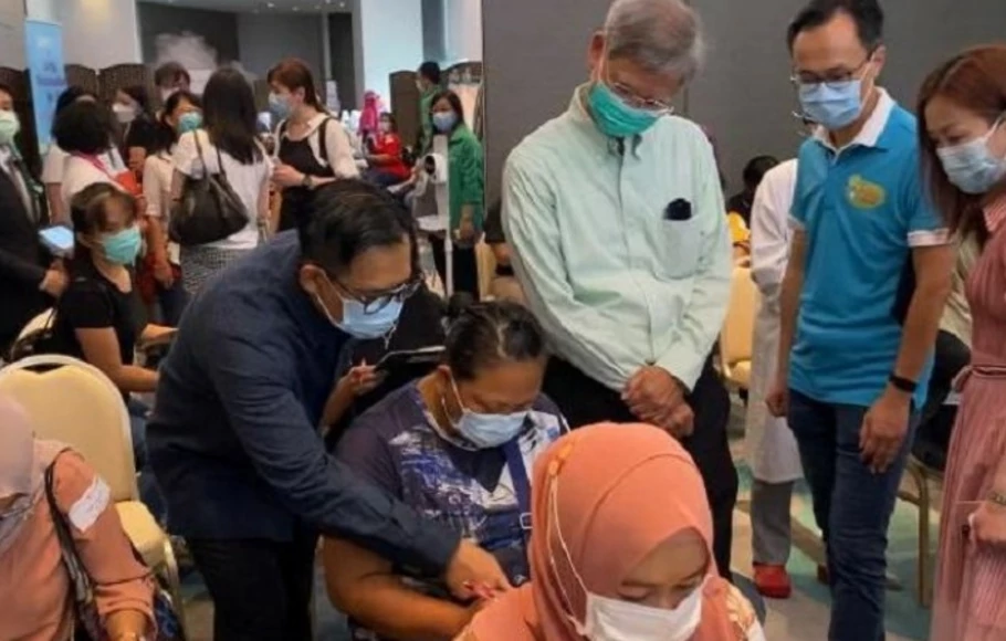 KJRI Hong Kong memberikan petunjuk kepada seorang pekerja migran asal Indonesia yang hendak menerima vaksin di kawasan Victoria Park, Hong Kong.