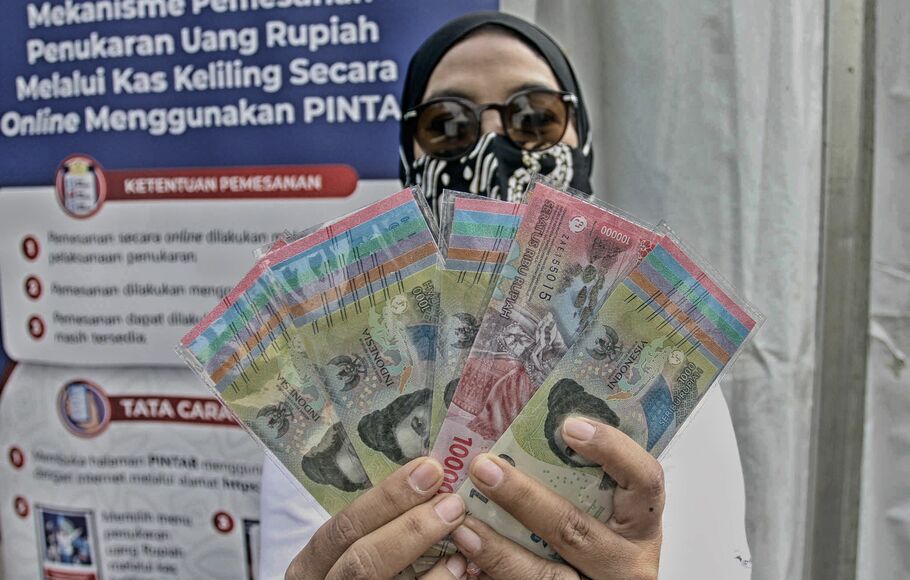Warga menunjukan uang Rupiah kertas Tahun Emisi 2022 usai ditukarkan dengan uang lama, di Gelora Bung Karno (GBK) Hall Basket, Jakarta, Minggu 21 Agustus 2022.