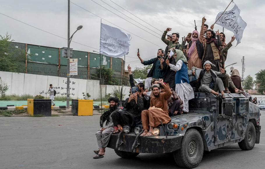 Pejuang Taliban memegang senjata saat mereka naik humvee untuk merayakan hari kemenangan mereka di dekat kedutaan AS di Kabul, Afghanistan pada Senin 15 Agustus 2022.