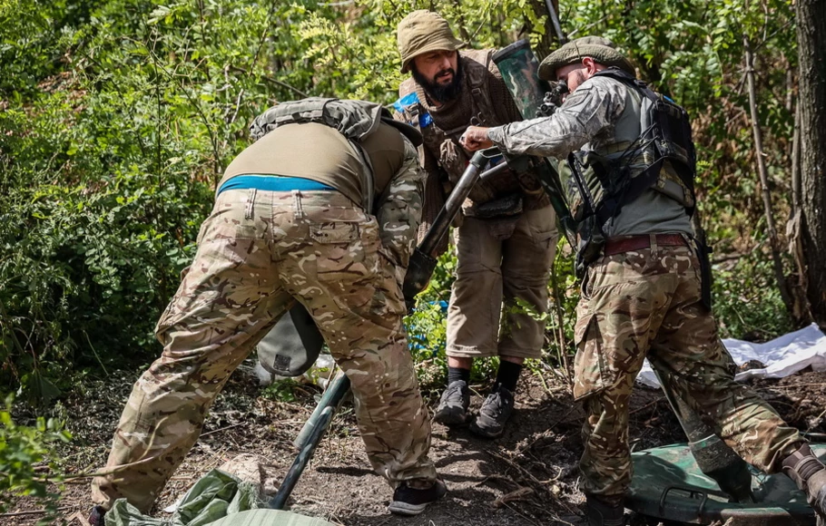 Pejuang sukarelawan Ukraina menyiapkan peluncur mortir pada posisi di sepanjang garis depan di wilayah Donetsk pada Senin 22 Agustus 2022, di tengah invasi Rusia ke Ukraina. Hampir 9.000 tentara Ukraina tewas sejak invasi Rusia pada 24 Februari, kata panglima tertinggi Ukraina pada 22 Agustus 2022. 